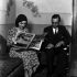Guz Águila entrevista a una mujer leyendo una revista en una sala, tomada de mediateca.inah.gob.mx, colección Archivo Casasola - Fototeca Nacional